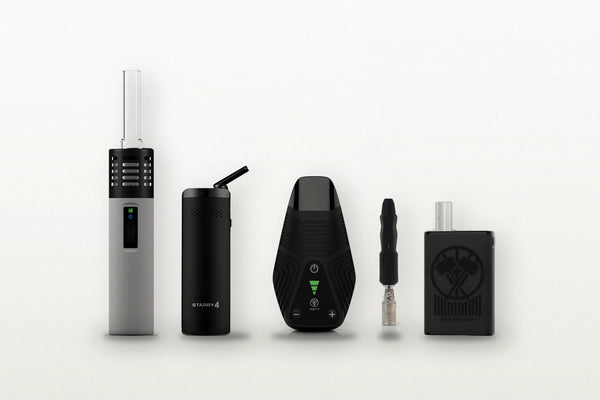 5 verschiedene Vaporizer stehen auf einem Tisch im Garten